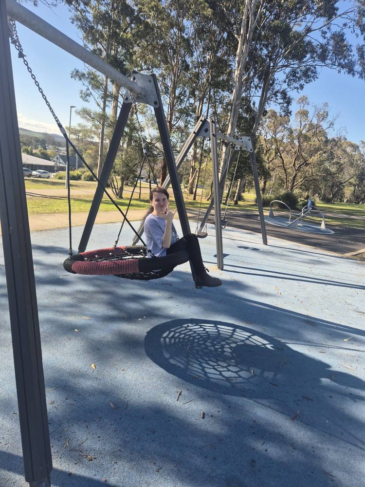 Relaxing on a basket swing at the park