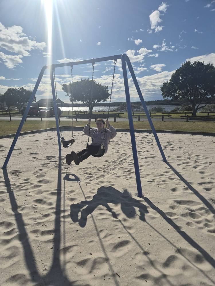 Swinging at a beachside playground on a sunny afternoon